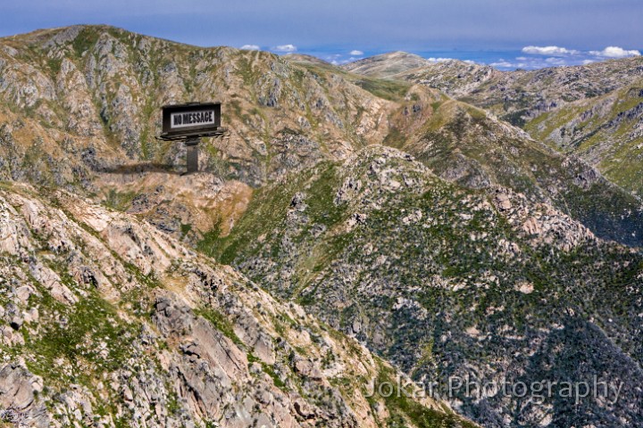 Watson Crags-2.jpg - Watson's Crags. Watson’s Crags lie on the steep western side of the Kosciuszko Main Range, between Mt Twynam and Mt Townsend. It’s a rugged and rarely visited part of the mountains, several hours walking or skiing from the nearest road or ski-lift access. In winter some intrepid skiers brave the steep slopes, and in summer there’s an occasional backcountry bushwalker, but mostly it’s left undisturbed by humans. Unlike much of the region, people have made no claim to the land, haven’t tried to ‘make use of it’, and are content to just let it ‘be’. So if this land could speak, I imagine that it might talk with its own voice, unsullied by any accretions of human projections or aspirations. In this image, a massive billboard allows the land to speak to us with its own voice, and its message is…. “No Message”.